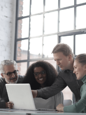 التواصل مع فريق الاتصال مجموعة من البالغين حول جهاز كمبيوتر محمول